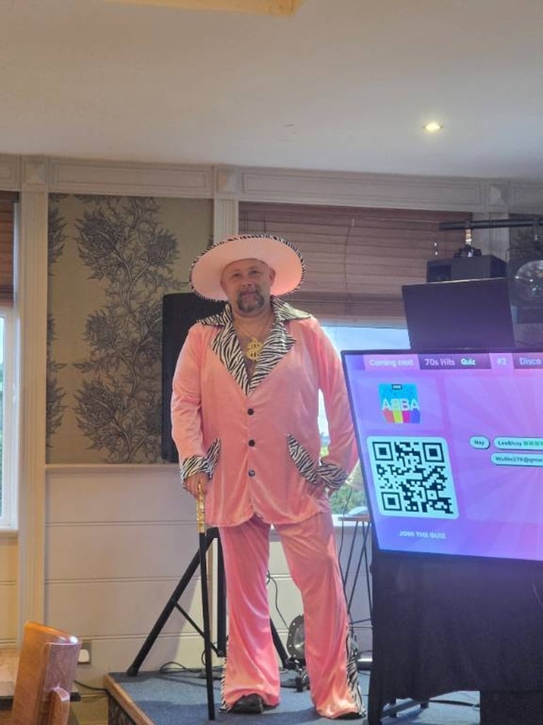 Guest in a pink seventies outfit