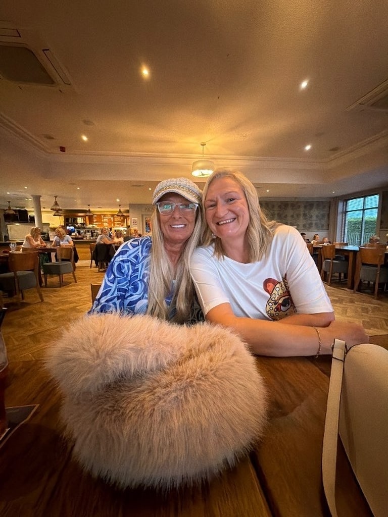 Two friends smiling at their table